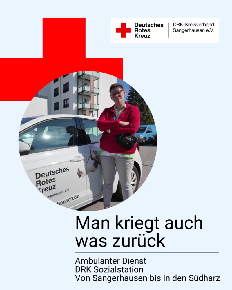 Eine Frau mit roter Jacke die an einem Auto anlehnt