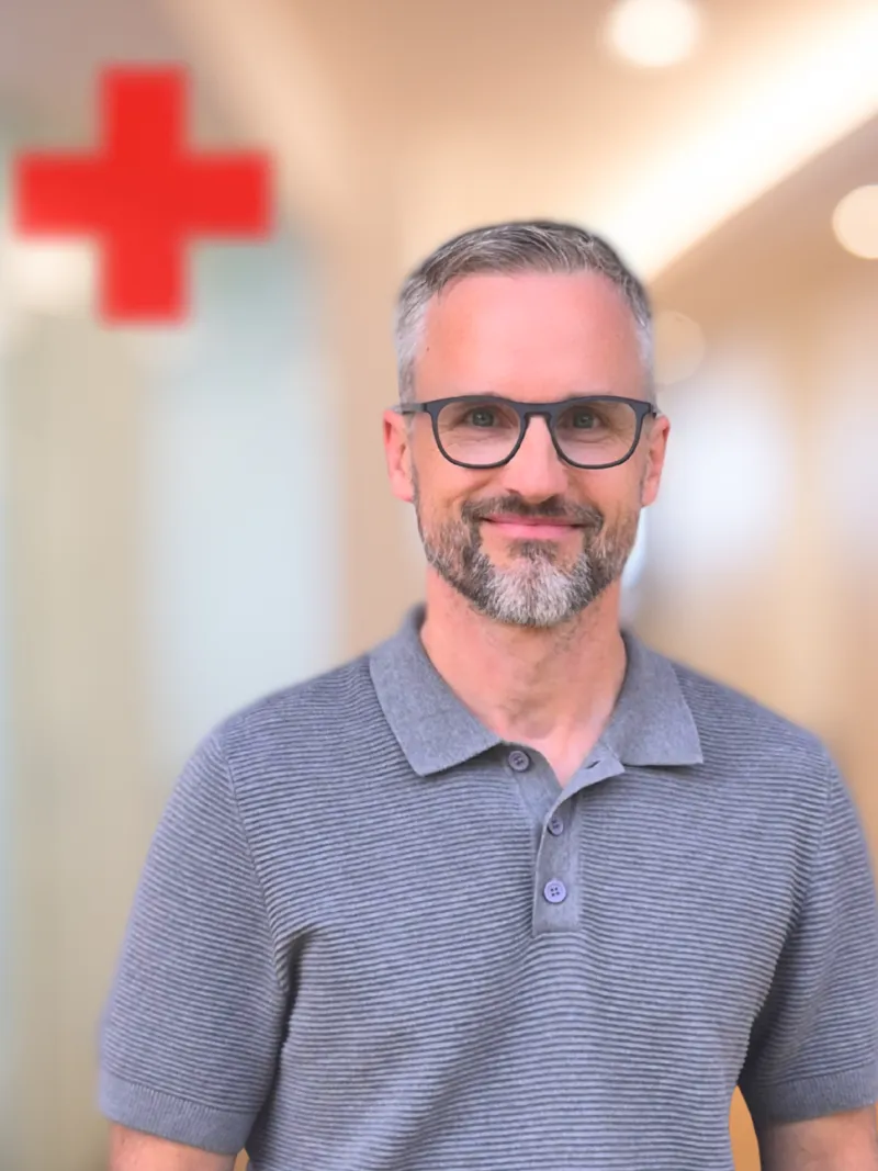 junger Herr der in die Kamera lächelt